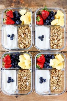 four plastic containers filled with granola, fruit and yogurt on top of a wooden table