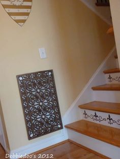 the stairs in this house are decorated with wrought iron designs and wood treads, along with a decorative panel on the wall