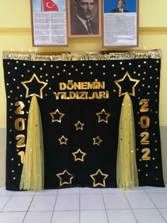 there is a black and gold banner with stars on it in front of two pictures