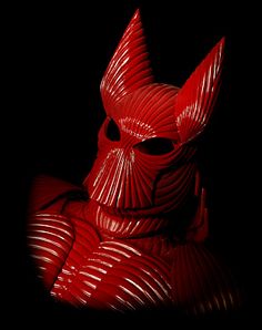 a red sculpture sitting on top of a black surface