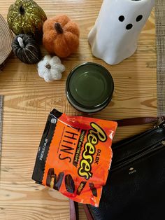 halloween items on a table including candy, pumpkins and ghost face mask for decoration