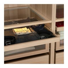 an open drawer in a wooden cabinet filled with items