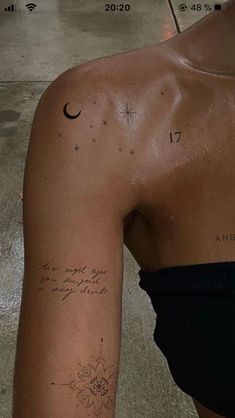 the back of a woman's arm with a tattoo on her left shoulder and an inscription written in cursive writing