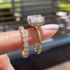 a close up of a person's hand holding an engagement ring