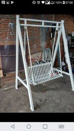 a white metal swing bed in front of a brick wall