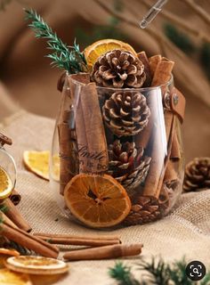 a glass filled with cinnamons and orange slices