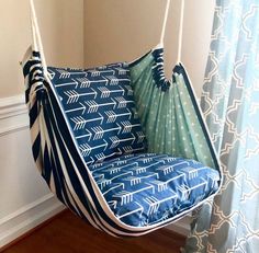 a blue and white hammock chair hanging from a ceiling