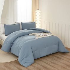 a blue comforter set on a bed in a room