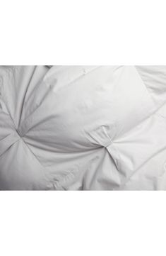 an unmade bed with white sheets and pillows