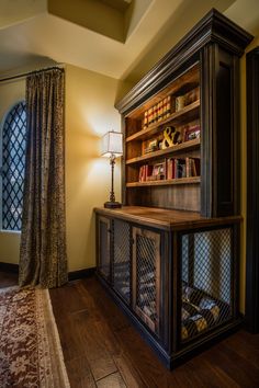 a book case in the corner of a room next to a lamp and a window