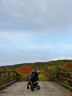 a baby stroller sitting on top of a wooden bridge