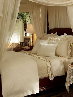 a bed with white sheets and pillows in a room