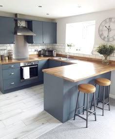 a kitchen with grey cabinets and wooden counter tops