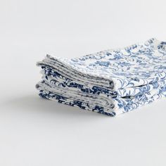 three blue and white napkins stacked on top of each other in front of a white background