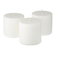 three white candles sitting next to each other