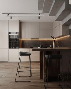 a kitchen with two stools next to a counter top and an oven in the background