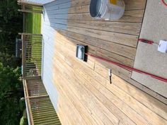 the outside of a house with wood siding and an air conditioner attached to it