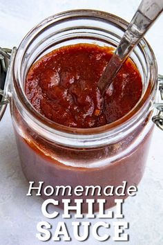 homemade chili sauce in a jar with a spoon sticking out of it and text overlay reads homemade chili sauce