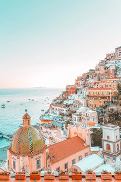 an aerial view of the ocean and buildings in positi, italy on a sunny day