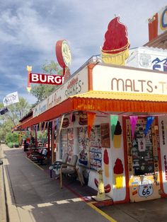 an ice cream shop with lots of signs on the side of it's building