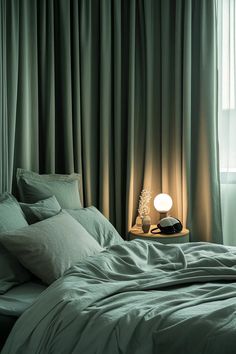 Master bedrooms sage green theme with thick curtains and bedside lamp emphasizing quality rest