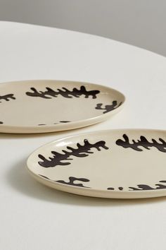 two black and white plates sitting on top of a table