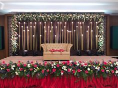 a stage set up with flowers and candles for a wedding or reception ceremony at the same time