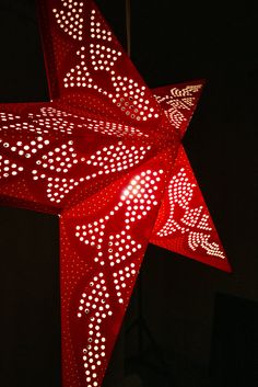 a red star hanging from the ceiling with white dots on it's sides and an upside down design