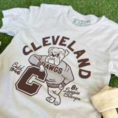 Designed and printed locally in Cleveland on a super soft heather dust unisex crewneck tee shirt with superior Airlume combed and ring-spun 100% cotton. *This product and its graphic design is not endorsed or licensed in any way by any team, or organization. SIZE BODY LENGTH CHEST WIDTH SLEEVE LENGTH CHEST TO FIT XS 27" 16.5" 8" 31"-34" S 28" 18" 8.25" 34"-37" M 29" 20" 8.625" 38"-41" L 30" 22" 9.5" 42"-45" XL 31" 24" 9.625" 46"-49" 2XL 32" 26" 10.25" 50"-53" 3XL 33" 28" 10.875" 54"-57" Retro Team Shirts, Varsity T-shirts, College Tee Shirts, Varsity Shirt Design, Graphic T Shirt Design Inspiration, Vintage Baseball Shirt, Vintage Sports Shirt, Alumni Tshirt Design Ideas, Sports Shirts Design