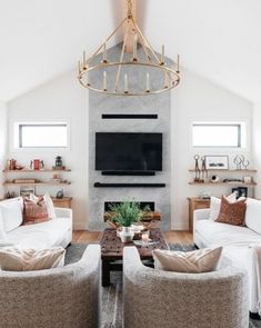 a living room filled with furniture and a flat screen tv mounted on the wall above a fireplace