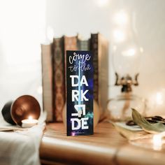 a book sitting on top of a wooden table next to candles and bookshelves