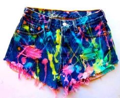 a pair of shorts with colorful paint splattered on the side and frayed at the bottom