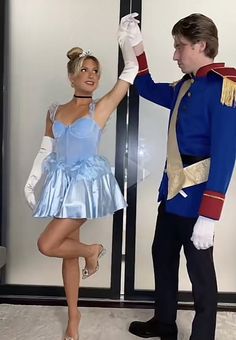 a man and woman dressed as nutcrackers are dancing in front of a glass door