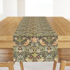 a wooden table topped with a green and yellow table cloth next to two wood chairs