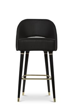 an upholstered black stool with gold legs