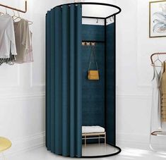 a room with a blue shower curtain next to a white wall and a gold purse hanging on the door