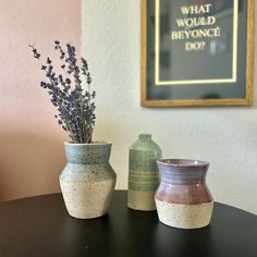 two vases sitting on top of a table next to each other with flowers in them