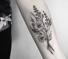 a black and white flower tattoo on the arm