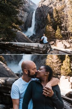 a man and woman are kissing in front of a waterfall while another person is sitting on a log