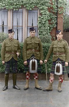 three men in kilts standing next to each other