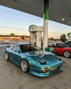 a blue car parked in front of a gas station