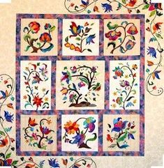 a quilted wall hanging with colorful flowers and leaves on it's sides,