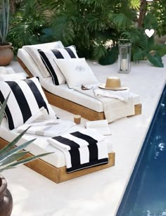 two lounge chairs sitting next to a swimming pool