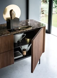 an open cabinet in the corner of a room with a vase and other items on it