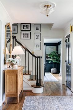 a hallway with pictures on the wall and a staircase leading to another room in the house