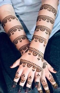 a woman's hands with henna tattoos on them