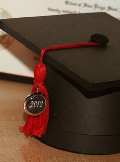 a graduation cap with a red tassel on it and the year 2012 hanging off