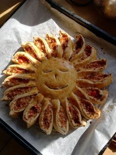 a smiley face pizza sitting on top of a pan