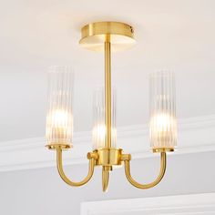 three lights hanging from a ceiling fixture in a room with white walls and trimmings