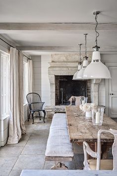 a dining room table and chairs in front of an open fire place with a fireplace